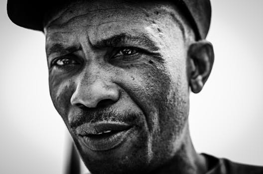 Close-up black-and-white portrait of a thoughtful African man in Tembisa, South Africa.